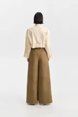 Pantalón sastrero de tiro alto, color verde oliva, de corte ancho y pierna recta. Presenta pliegues frontales y bolsillos funcionales.