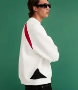 Saco deportivo boxy de algodón felpa color blanco, con cuello redondo, manga raglán larga y recortes rojos en los hombros. Presenta bordados frontales con texto "OFFICIAL NATIONAL MAJOR HARMONY", un logo circular y el número "31". Las mangas tienen un patrón de cuadros rojos y blancos.