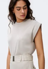 Camiseta sin mangas de tejido de punto fino, color gris claro, con cuello redondo y hombreras sutiles que aportan estructura.