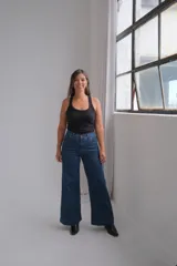 Jean de tiro alto y corte wide leg, confeccionado en denim azul oscuro con costuras en contraste.