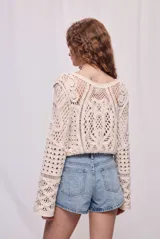 Short de jean blanco de tiro alto y calce relajado, con bolsillos delanteros y traseros, costuras marcadas y cierre frontal con botón y cremallera.