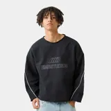 Buzo negro de corte oversize con cuello redondo, mangas largas con costuras laterales blancas y bordes desflecados.