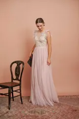 Vestido largo de tul plumetí en color rosa suave, con detalles de encaje bordado en el torso y volados en los hombros.