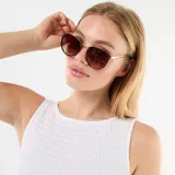 Musculosa blanca de tejido elástico tipo smock, sin mangas, con cuello redondo y dobladillo con volados.