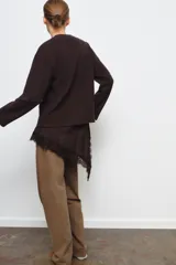 Vestido de punto con cuello redondo y manga larga, que presenta un bajo asimétrico de satén con detalle de encaje a tono.