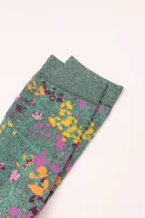 Calcetines de caña media color verde con glitter y estampado de flores en tonos amarillo, naranja, rosa y violeta.