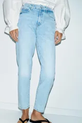 Jeans de tiro alto con corte mom fit, cinco bolsillos y cierre frontal con cremallera y botón.