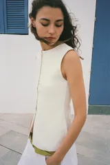 Top tipo chaleco confeccionado en hilatura con viscosa, con diseño de rayas horizontales en blanco y azul marino. Presenta cuello redondo, manga sisa y cierre frontal con botones.