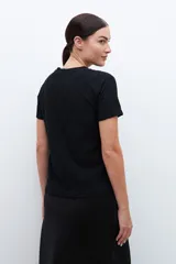 Blusa negra de broderie con mangas cortas y cuello redondo.
