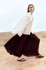 Pollera larga de corte holgado en modal, color marrón, con cintura elástica de tiro alto y frunces alrededor que aportan volumen.