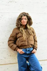 Campera puffer color marrón, con capucha desmontable con borde de piel sintética, cierre frontal y bolsillos laterales con cierre.