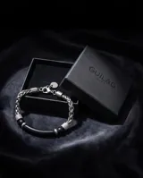 Pulsera masculina compuesta por una barra central de piedra onix negra, flanqueada por piezas de acero con textura grabada y esferas metálicas. Diseño elegante y moderno con cierre ajustable.
