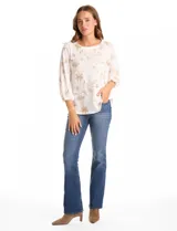 Blusa de tejido fino color marrón con bordado floral en hilo dorado. Presenta cuello redondo, mangas tres cuartos abullonadas con puños elásticos fruncidos y ruedo redondeado con corte asimétrico.