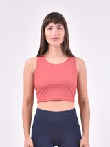 Top deportivo tipo crop top de cuello redondo y corte sin mangas, confeccionado en tejido elástico de color cereza.