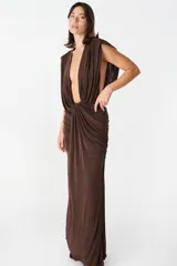 Vestido largo color chocolate, con escote profundo drapeado y falda con frunces laterales que aportan movimiento.