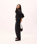 Pantalón de jean color negro con corte baggy y cintura media. Presenta estrellas bordadas con acabado desflecado en las piernas y bolsillos funcionales.