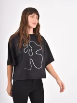 Remera negra de corte holgado con estampa frontal de línea abstracta en color blanco.