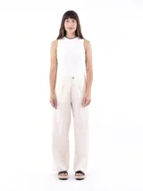 Pantalón de corte recto y tiro alto, confeccionado en tela liviana color crudo. Presenta bolsillos frontales tipo parche y cierre con botón central.