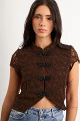 Top de encaje marrón de manga corta y cuello alto, con cierre frontal de nudos chinos negros y diseño ajustado.