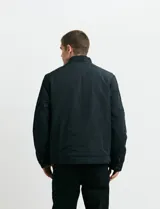 Campera de estilo casual con cierre frontal, cuello alto con broche y bolsillos laterales con cierre. Presenta un diseño liso y funcional, ideal para uso diario.