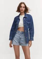 Short mom-fit de tiro alto confeccionado en tejido de algodón estilo vaquero, con diseño de cinco bolsillos, cierre de cremallera y botón, y bajo con vuelta.
