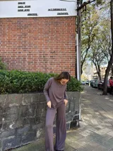 Conjunto de dos piezas de color marrón, compuesto por un buzo holgado de manga larga con escote redondo y un pantalón de corte amplio.