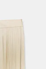 Pantalón de tiro medio confeccionado en tejido satinado verde, con diseño bombacho y bajos acabados en puño elástico. Cuenta con cierre lateral con cremallera oculta en costura.