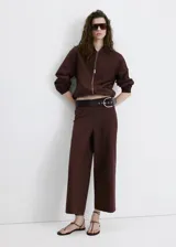 Pantalón marrón de corte recto y tiro medio, confeccionado en mezcla de lino, viscosa y algodón. Cuenta con diseño largo y cintura elástica.