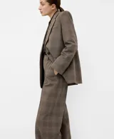 Blazer de corte sastrero con diseño a cuadros, confeccionado en una mezcla de lana, poliéster, viscosa y elastano. Presenta solapas clásicas, cierre frontal con un botón y bolsillos laterales con solapa.