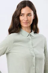 Camisa de lino lisa de manga larga, con cuello clásico y cierre frontal de botones.