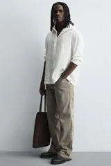 Zapato tipo náutico color negro, con parte superior lisa, bordón y horma redonda. Cuenta con suela de volumen y piso track.