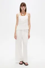 Pantalón blanco de viscosa, de corte ancho y tiro alto, con bolsillos laterales.