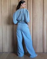 Pantalón de corte recto y holgado, confeccionado en denim azul. Presenta cintura elástica con cordón de ajuste y bolsillos laterales.