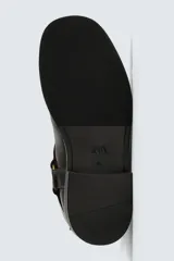 Bota de caña media fabricada en piel color negro, con detalle de arnés y hebilla metálica lateral. Presenta horma cuadrada y suela a tono con ligero tacón.