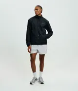 Campera deportiva reversible de manga larga con cierre frontal de cremallera, cuello alto y bolsillos laterales. Confeccionada en poliamida con forro interior de fleece, presenta un pequeño logo estampado en el pecho.