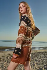 Musculosa tejida a crochet con diseño calado multicolor en tonos marrón, beige y negro.