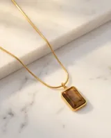 Collar de acero con baño de oro, compuesto por una cadena fina y un dije rectangular con piedra natural ojo de tigre.