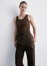 Pantalón de jean color marrón oscuro, de corte recto y tiro medio. Presenta una hilera de tachas metálicas plateadas a lo largo de la costura lateral externa.