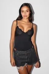 Body negro con breteles finos, parte superior de encaje y parte inferior lisa.