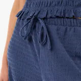 Pantalón ancho azul de punto smock, con cintura elástica ajustable mediante cordón del mismo tejido y diseño fluido de perneras holgadas.