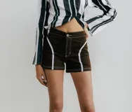 Short de denim marrón con apliques blancos en el frente.