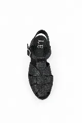 Sandalias de cuero negro con diseño de tiras trenzadas artesanales en la parte delantera, plantilla de cuero y tira ajustable al tobillo con hebilla metálica.