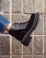 Borcego de cuero color suela con puntera redondeada, cierre mediante tiras de velcro y suela track de goma negra.