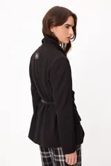 Blazer de largo medio con terminaciones clásicas, diseño sin cruce frontal y cinto de cuero fino incorporado para ajuste en la cintura.