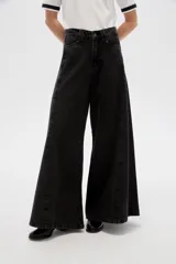 Pantalón jean de tiro alto y corte ancho tipo wide leg, con bolsillos y cierre frontal.