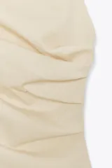 Top color fucsia de escote recto y tirantes finos, con detalle de pliegues y espalda descubierta. Cierre con lazadas en la espalda.