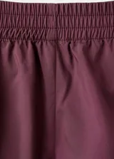 Short deportivo de corte retro, color bordó con ribetes blancos en los bordes y cintura elástica.