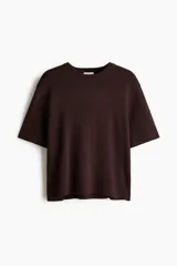 Remera de punto color marrón oscuro, de textura tupida, con cuello redondo acanalado, mangas cortas con hombros caídos y bajo recto.