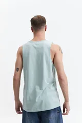 Musculosa de algodón color verde agua, con cuello redondo y estampado frontal con la frase 'Amplify your strength'.