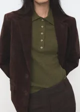 Jersey de punto verde militar con cuello polo y cierre frontal parcial con botones. Presenta manga larga y diseño de corte recto.